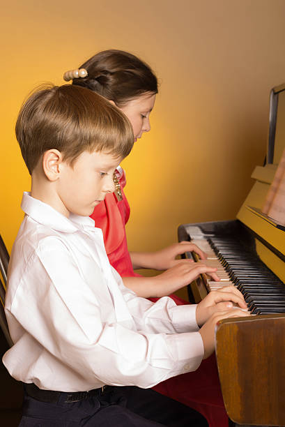istock Brother And Sister Playing Piano. Piano player. 506870024
