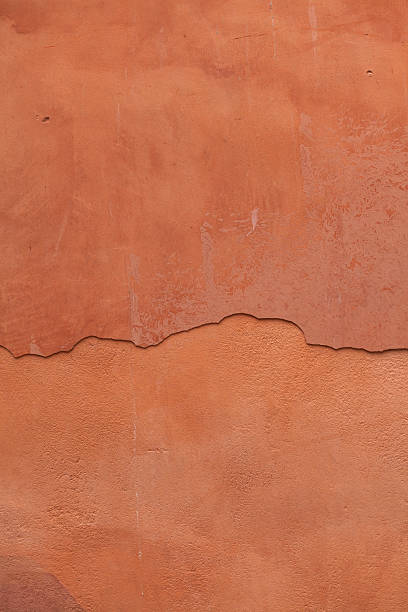 istock Old terracotta painted stucco wall with cracked plaster. Backgro 506871744