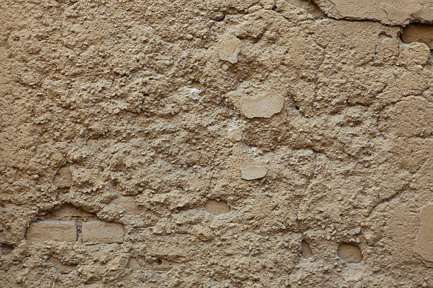istock Old ochre painted stucco wall with cracked plaster. Background t 506871886