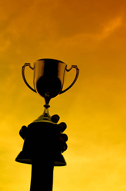 istock silhouettes boy with a cup and sun set natural light. 506876058