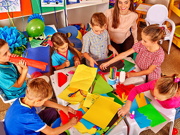 istock Female kid work with colored paper in beginner school 506876552