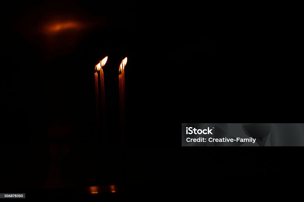 two candles burning in the dark two candles burning in the complete darkness Black Background Stock Photo