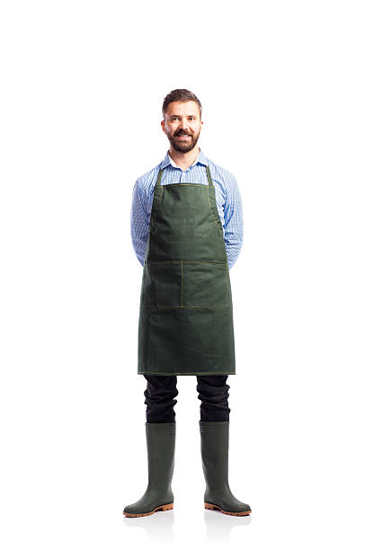 Young handsome gardener Young handsome gardener in green apron. Studio shot on white background apron stock pictures, royalty-free photos & images