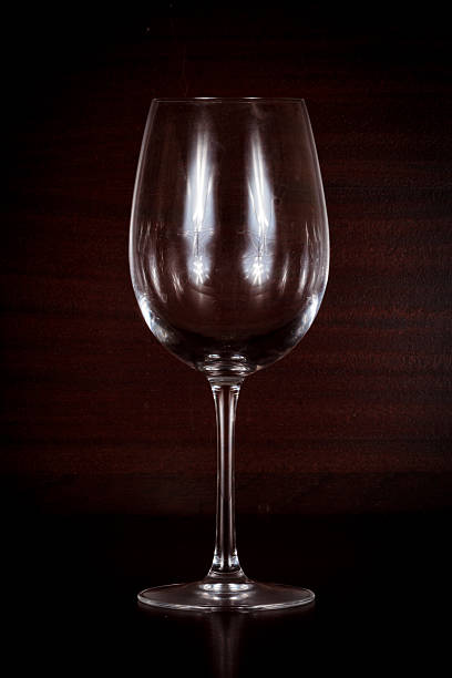 istock Empty wine glass isolated on wood background 506883450