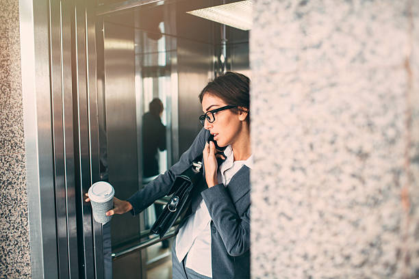 istock Businesswoman On The Phone In The Elevator 506884004