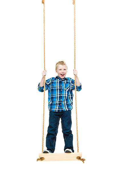 istock Smiling little boy swinging 506884556