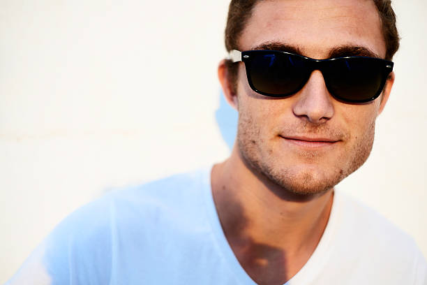 istock attractive young man looking at the camera with sun glasses 506889757