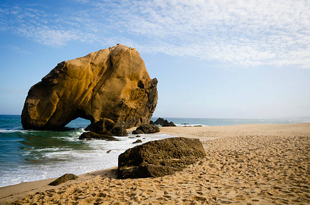 Penedo do Guincho - Santa Cruz Beach, near Lisbon, Portugal; towering rock 98 feet high and 328 feet in circumference with a crack at its base.