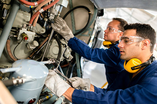 Mechanics fixing a helicopter Mechanics fixing the engine of a helicopter airplane maintenance stock pictures, royalty-free photos & images