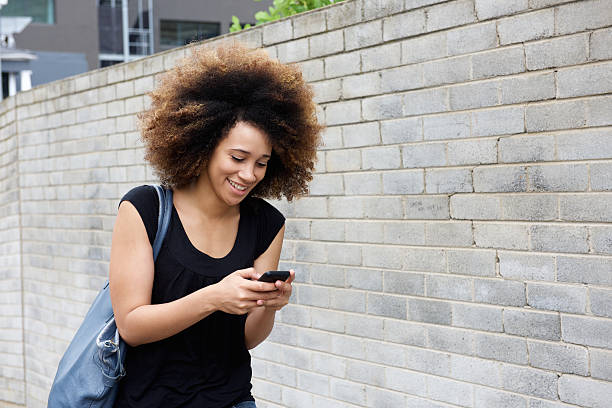 istock Young woman walking and sending text message 506892592