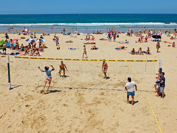 hombres jóvenes jugando voleibol de playa zurriola, san sebastián. españa. - volleyball volleying human hand men fotografías e imágenes de stock