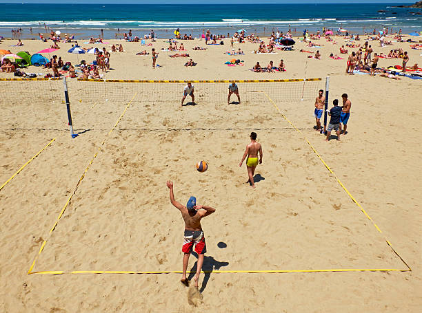 hombres jóvenes jugando voleibol de playa zurriola, san sebastián. españa. - volleyball volleying human hand men fotografías e imágenes de stock