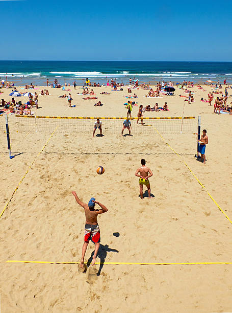 hombres jóvenes jugando voleibol de playa zurriola, san sebastián. españa. - volleyball volleying human hand men fotografías e imágenes de stock