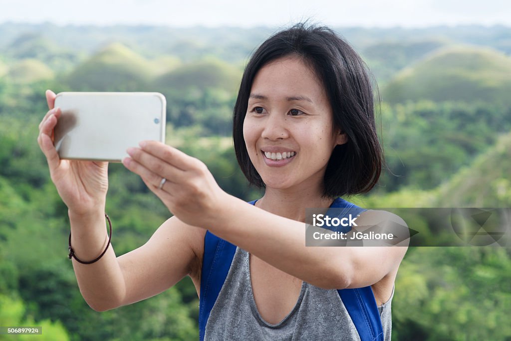 Woman taking a selfie Woman taking a selfie using her phone. Cebu, Philippines. December 2015 Philippines Stock Photo