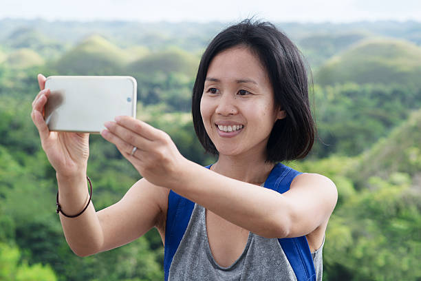 Woman taking a selfie Woman taking a selfie using her phone. Cebu, Philippines. December 2015 chocolate hills photos stock pictures, royalty-free photos & images
