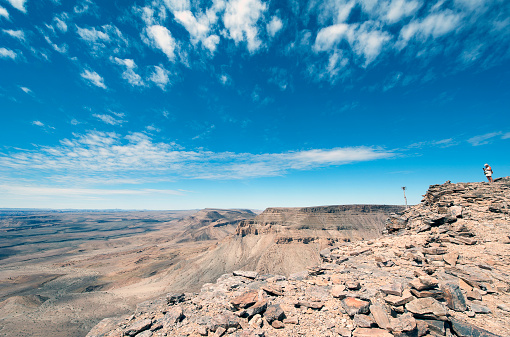 Fish River Canyon hiker looks to the horizon as the second largest canyon on earth, Namibia, Africa