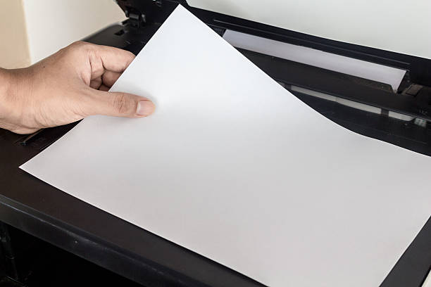 istock Hand holding paper sheets into printer tray 506898750