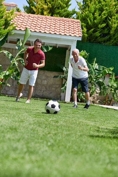 istock Father and son playing football 506900326