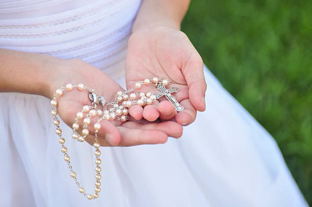 Rosary in Girl's hands stock photo