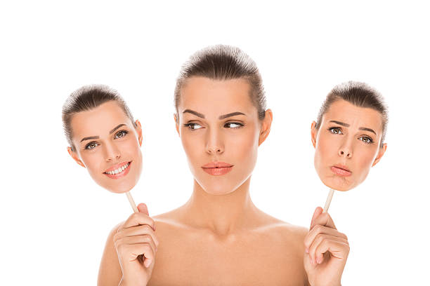istock Woman holding happy and sad face mask 506909433