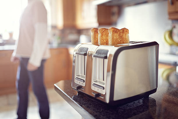 Early morning breakfast toast Early morning toasted bread, man in the kitchen preparing toast for breakfast at sunrise drudgery photos stock pictures, royalty-free photos & images