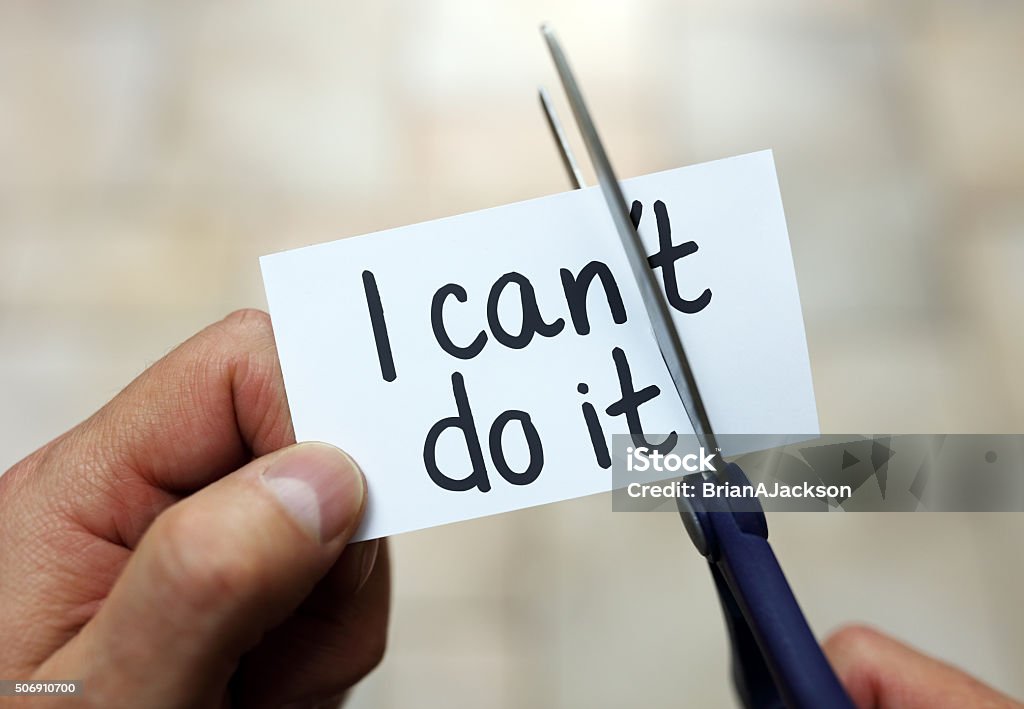 I can do it Man using scissors to remove the word can't to read I can do it concept for self belief, positive attitude and  motivation Confidence Stock Photo
