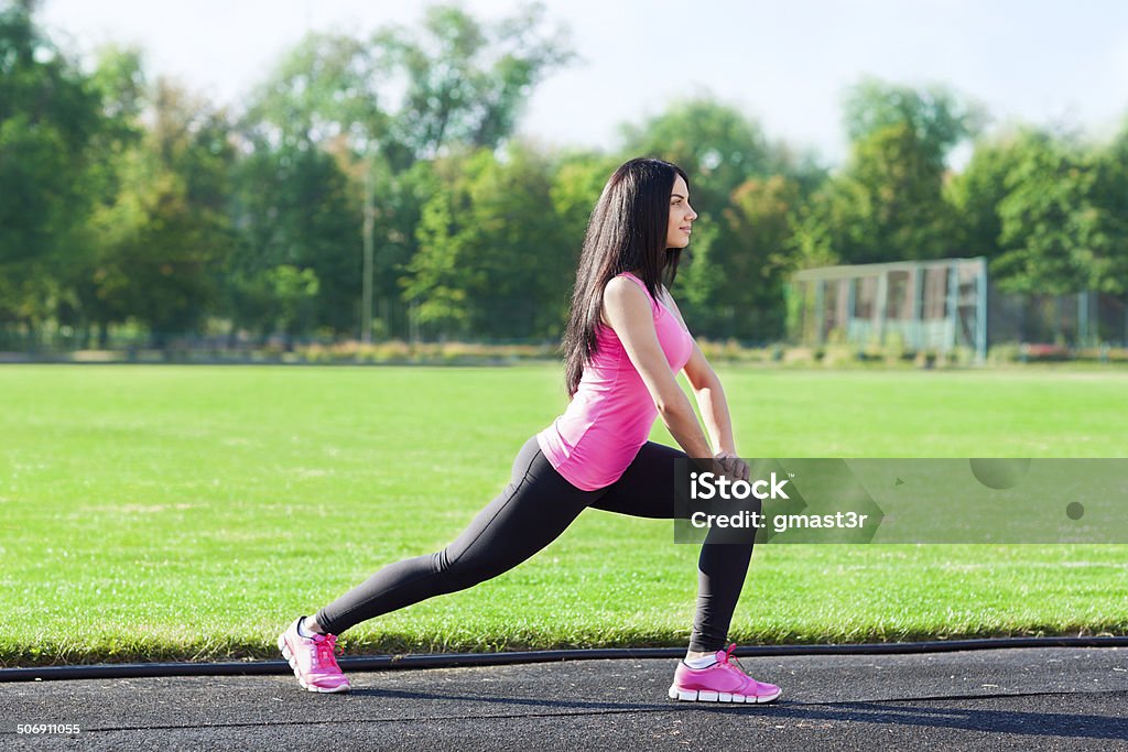 woman sport on stadium leg stretching exercises woman sport on stadium summer outdoors training, girl doing leg stretching exercises Active Lifestyle Stock Photo