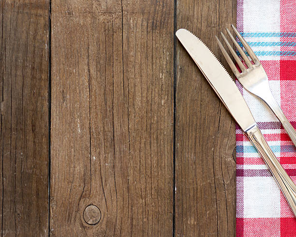 istock Fork and knife on kitchen towel and old wooden table 506911259