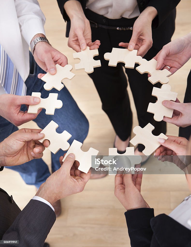 Business People Holding Jigsaw Puzzle High Angle View Of Business People Assembling Jigsaw Puzzle Jigsaw Puzzle Stock Photo
