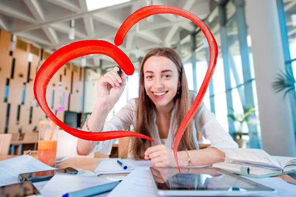 Girl drawing heart shape in the University class