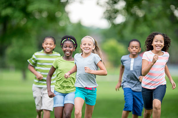 enfants courir dans l'herbe - summer recreation photos et images de collection