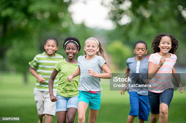 Children Running Through The Grass Stock Photo - Download Image Now - Child, Jogging, Running