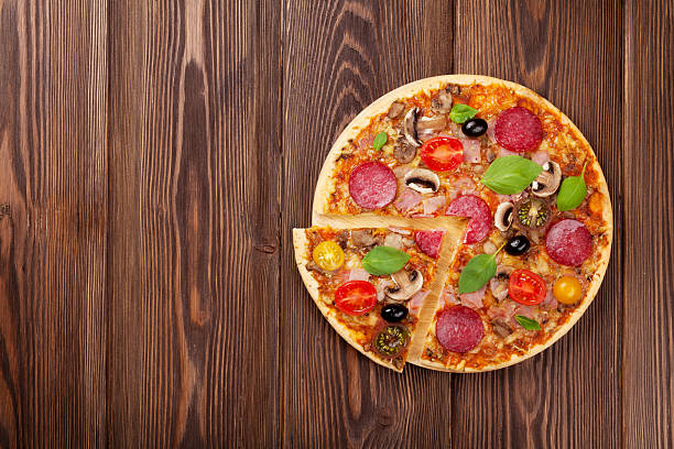 istock Italian pizza with pepperoni, tomatoes, olives and basil 506913986