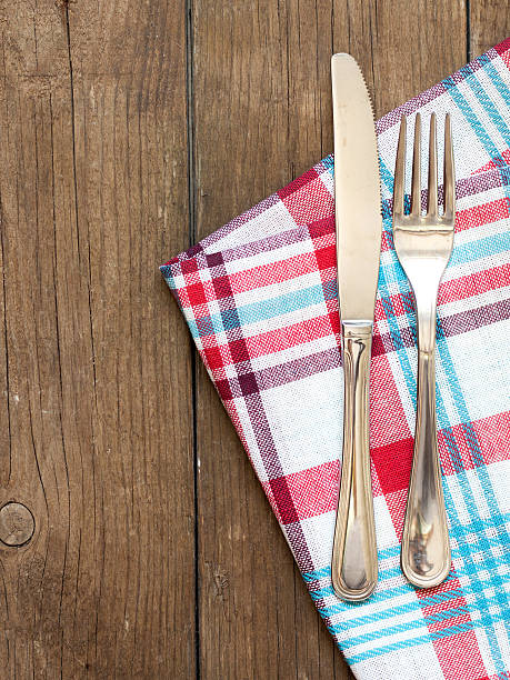 istock Fork and knife on kitchen towel and old wooden table 506914631