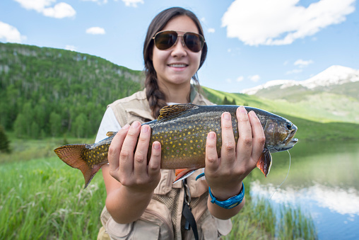 Girl Holding trout in summer Colorado