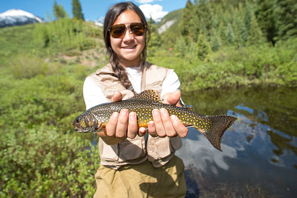 Girl Holding trout in summer Colorado