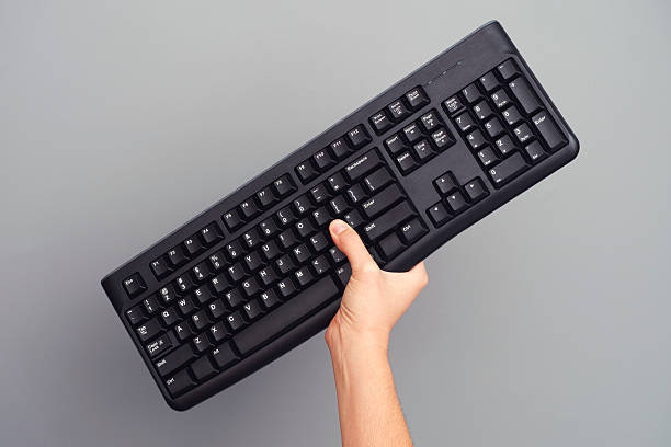 istock Person holds black wireless keyboard in her hand 506915532