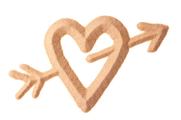 sign of love with heart and Cupid arrow sculptured in sand