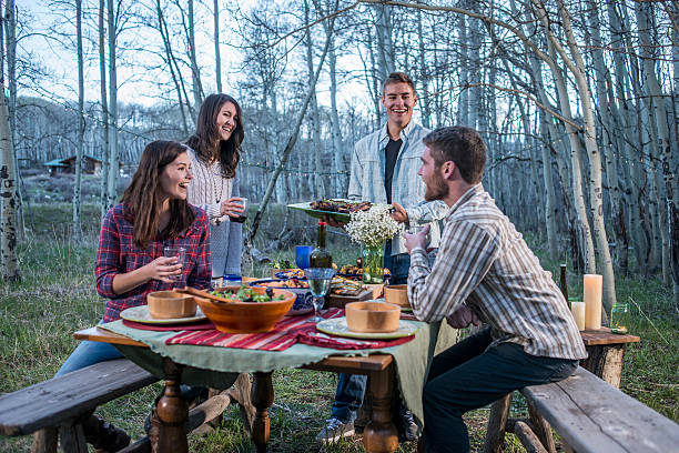 istock Young adults at outdoor dinner party in forest 506916588
