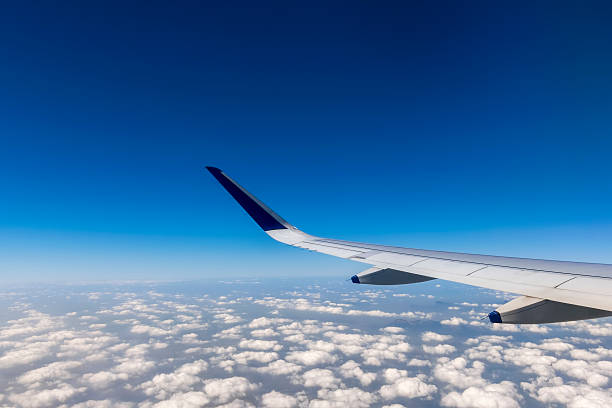 istock Wing of a flying passenger airplane above clouds 506916710