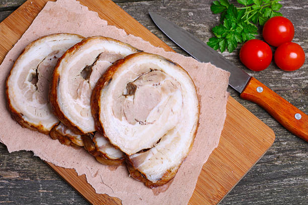 istock Sliced roasted roll pork loin with spices and fresh vegetables 506917274