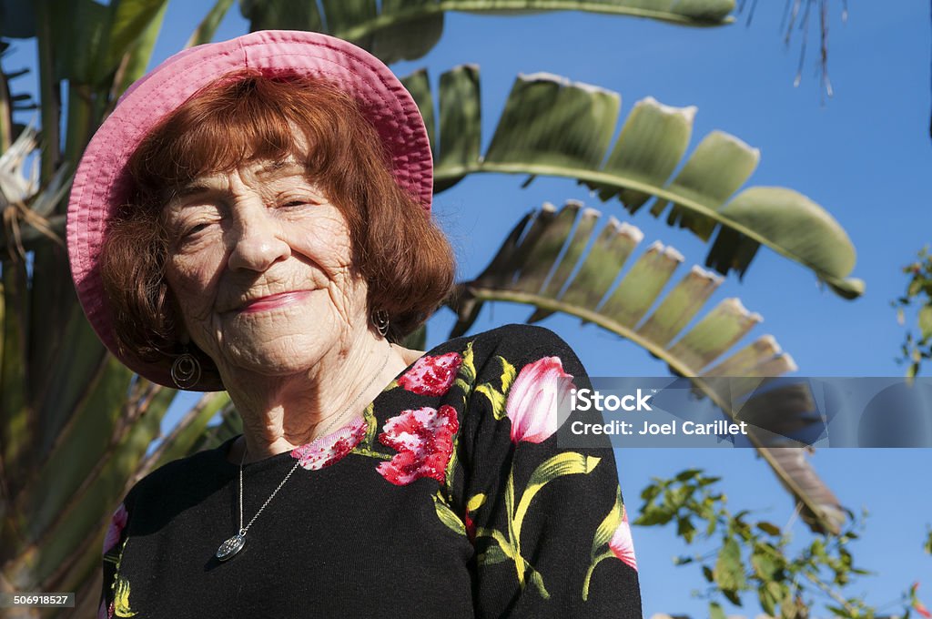 Portrait of senior woman in pink hat outdoors in Florida A senior woman in a sunny backyard in Florida 80-89 Years Stock Photo