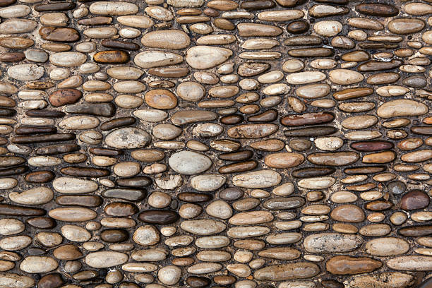 istock Cobbled pavement made of river rounded pebbles. Background textu 506919442