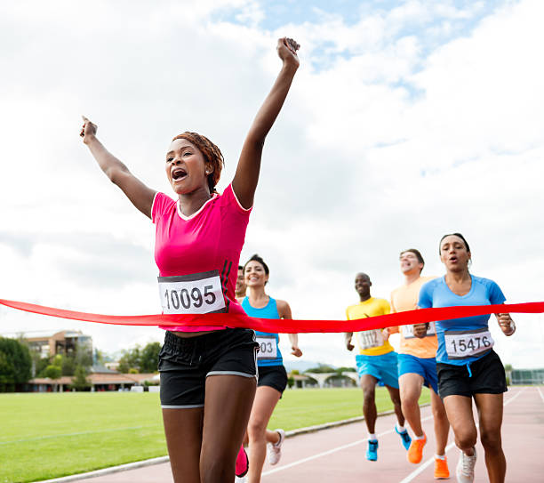 frau einen marathon zu laufen - überqueren stock-fotos und bilder