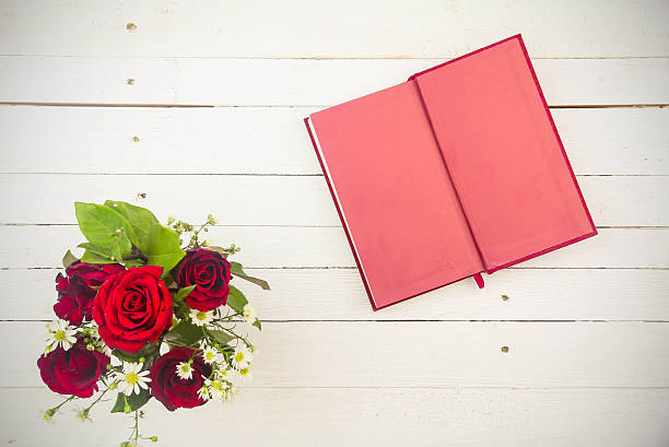 istock red roses and red diary on white wooden background 506921836