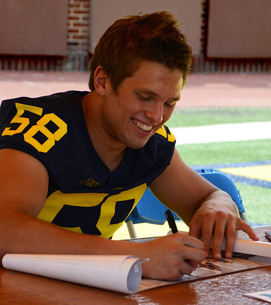 UM football player 58 Chase Winovich Ann Arbor, MI - August 10, 2014: University of Michigan football player Chase Winovich pauses between autographs at Michigan Football Youth Day on August 10, 2014 in Ann Arbor, MI. michigan football stock pictures, royalty-free photos & images