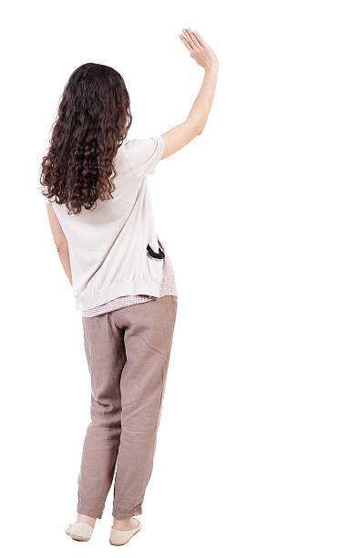 Back view of curly woman welcomes. Back view of curly woman welcomes. Young teenager girl hand waving from. Rear view people collection. backside view of person. Isolated over white background. Curly girl waving good-bye. pics of girls buttocks stock pictures, royalty-free photos & images