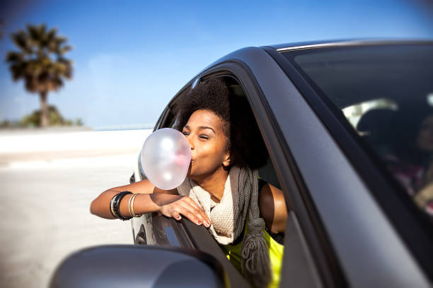 mujer jugando con goma de mascar en un viaje por carretera - chewing gum women bubble blowing fotografías e imágenes de stock