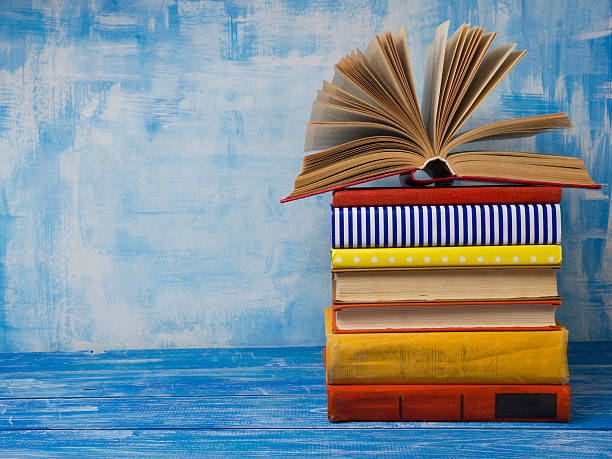 istock Open book, hardback books on abstract blue background at wooden 506924294