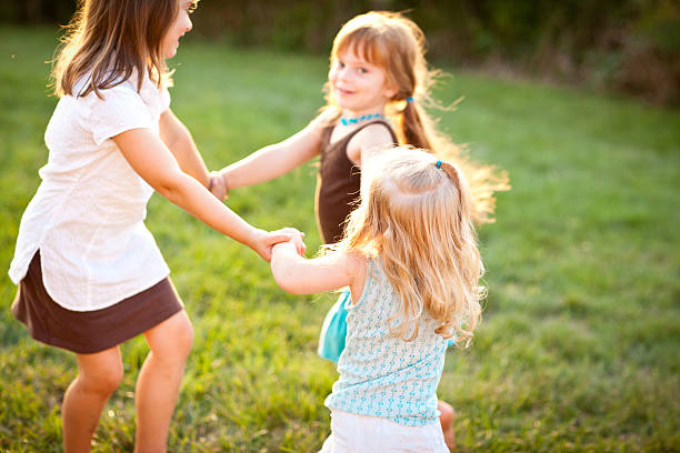 istock Three Happy Girls Holding Hands While Spinning Outside 506925408